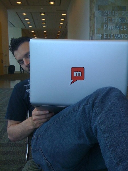 Coding on a MacBook with the Mellmo logo sticker